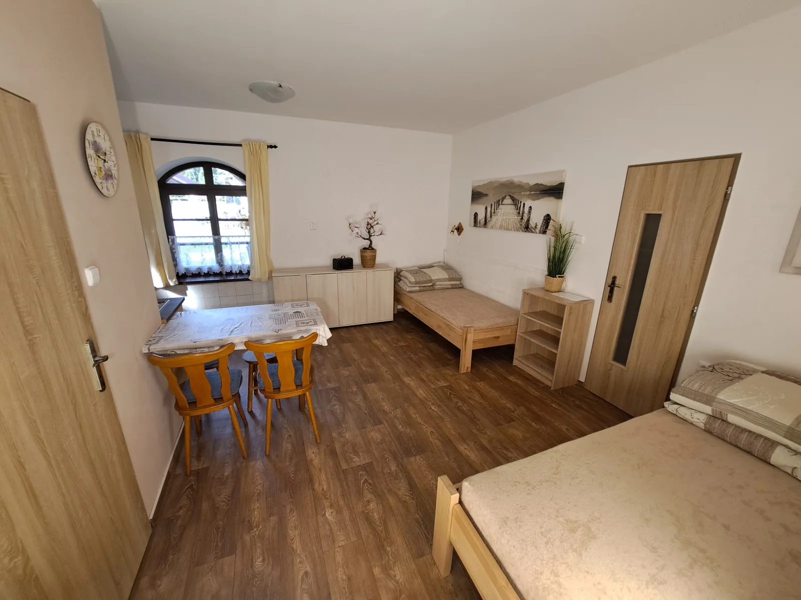 Apartmán č. 1 — pokoj s jídelním stolem, samostatným lůžkem a manželskou postelí