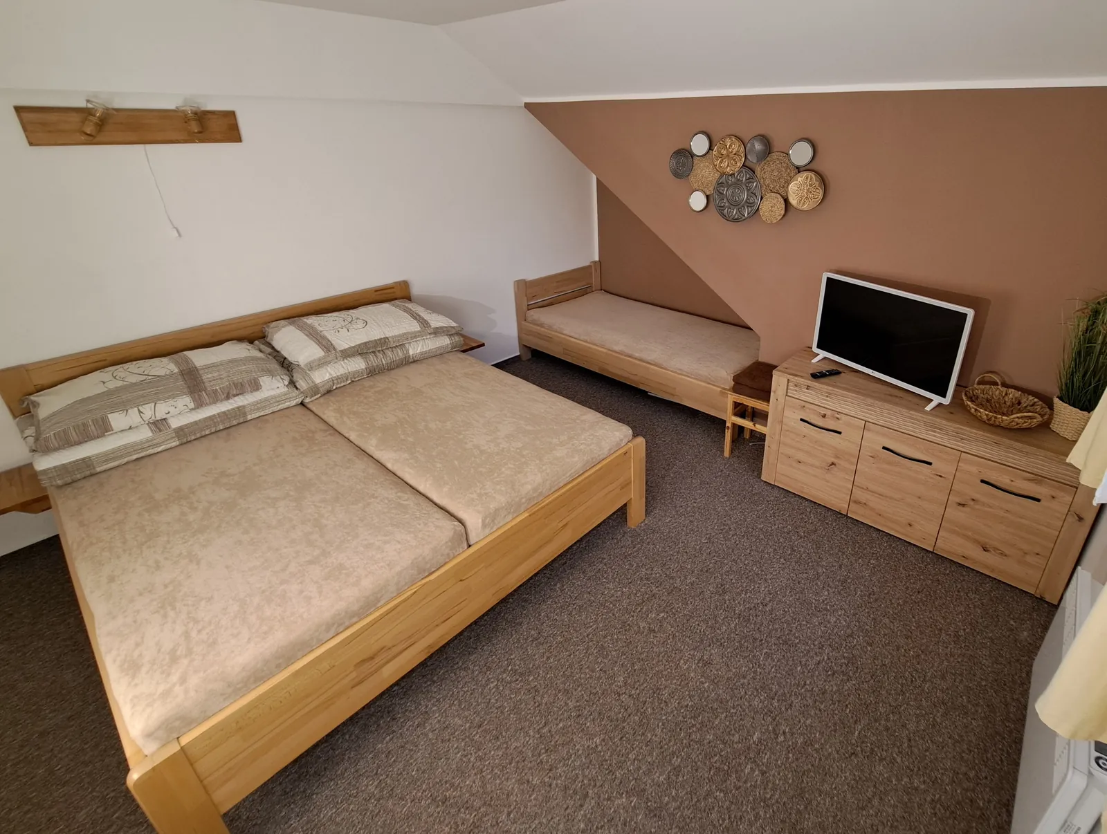 Apartmán č. 2 — ložnice s manželskou postelí, samostatným lůžkem a televizí